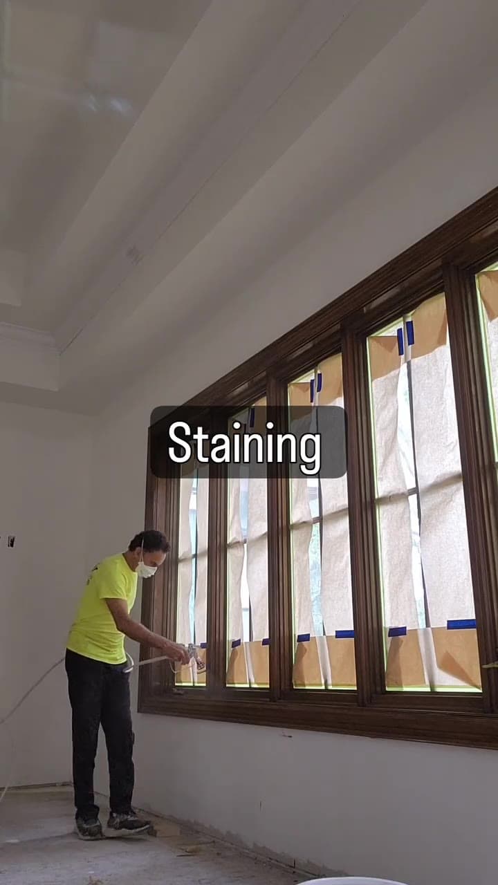 Pawmir painter staining large window trim